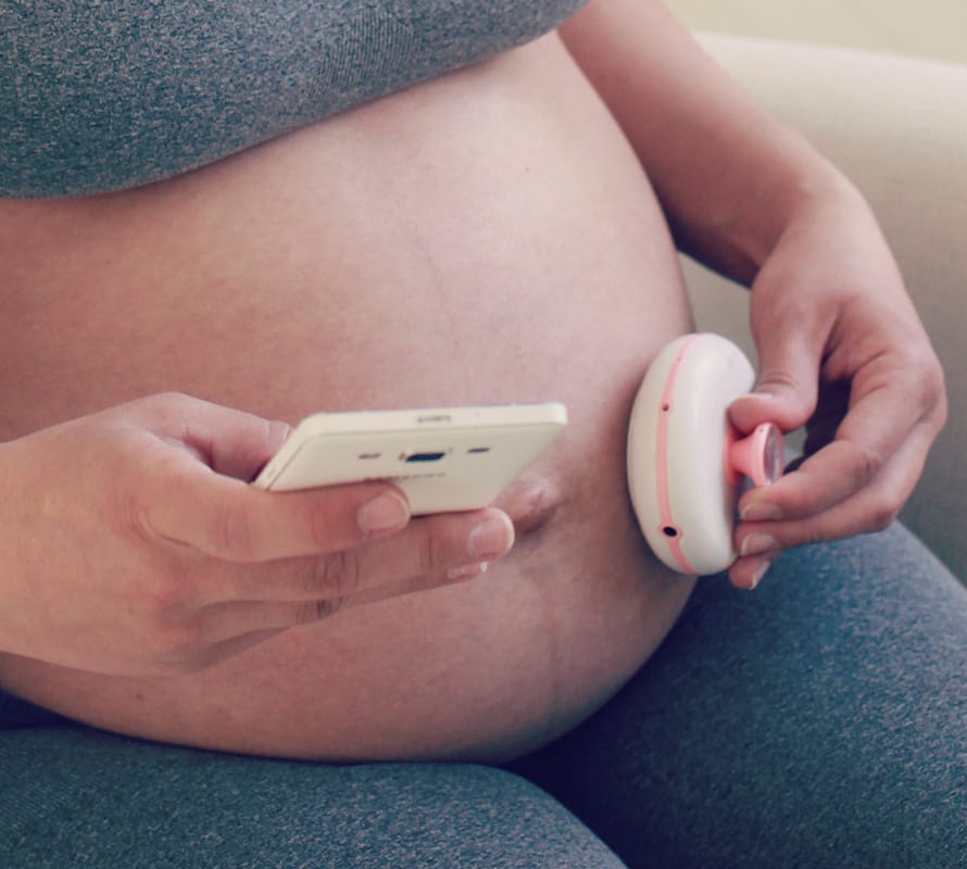 pregnant woman using BabyCTG sensor and application
